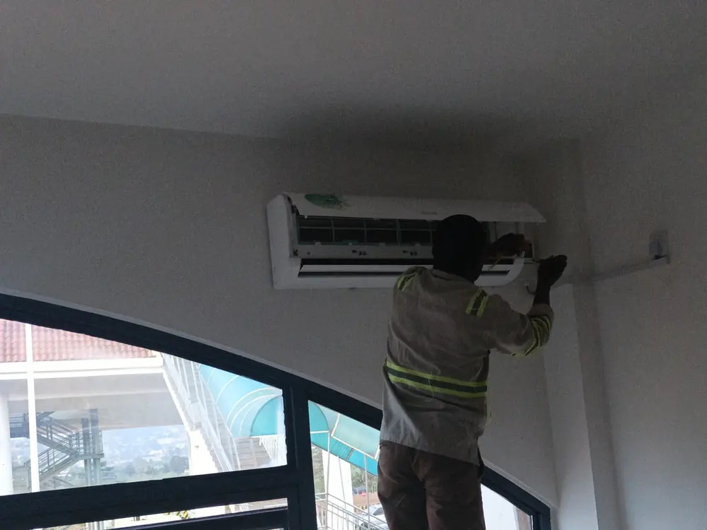 Technician servicing a wall-mounted air conditioner