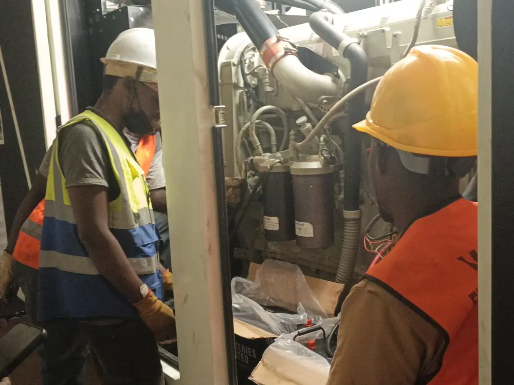 Technicians working inside a generator enclosure